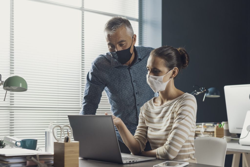 Business people working together and wearing face masks Business people working together and wearing face masks