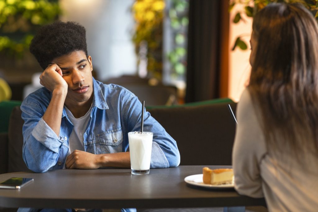 Bored black guy listening to his girlfriend