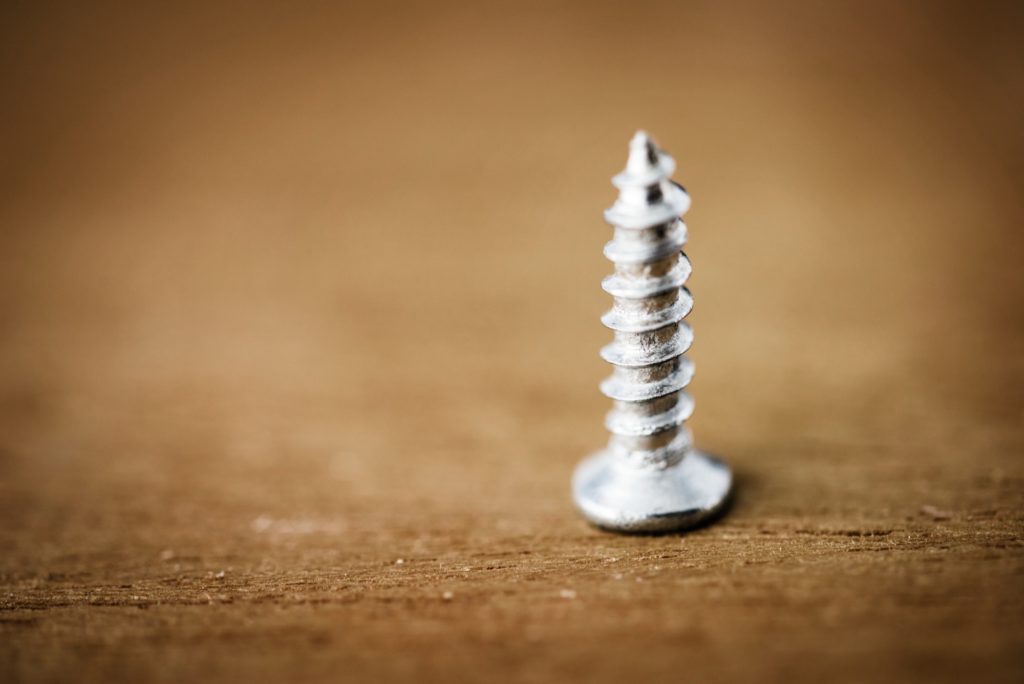 Macro shot of screw on wooden background