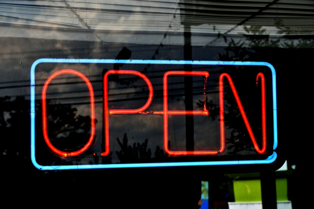 Neon OPEN sign in teal and orange - Yes, we're open for business