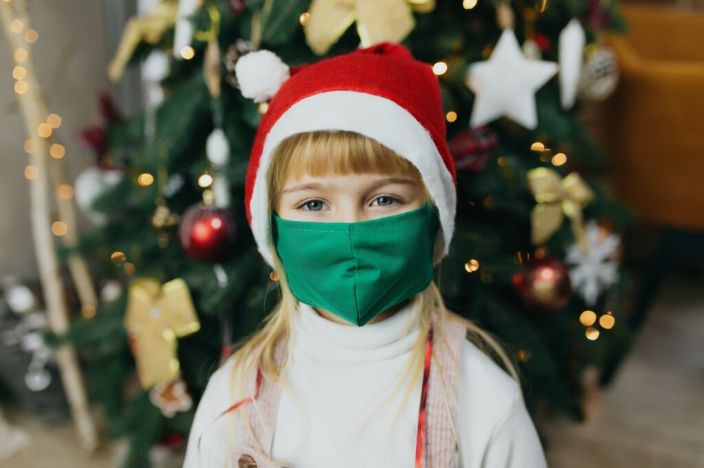 Girl in Santa's hat and mask, christmas time, lockdown in holidays, covid-19