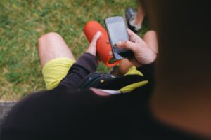 Traveler using his smartphone and wireless speaker to listen to music