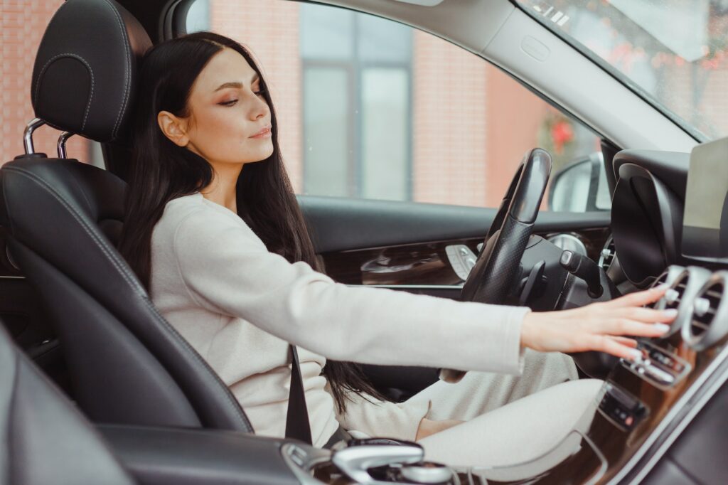 Woman turning on car air condition system on dashboard in car panel, Auto car air condition