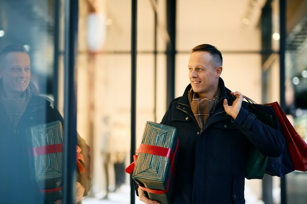 Happy man enjoying in window shopping for Christmas holidays. Happy man enjoying in window shopping for Christmas holidays.