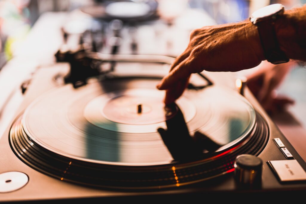 Dj hands on equipment deck and mixer with vinyl record at party Dj hands on equipment deck and mixer with vinyl record at party