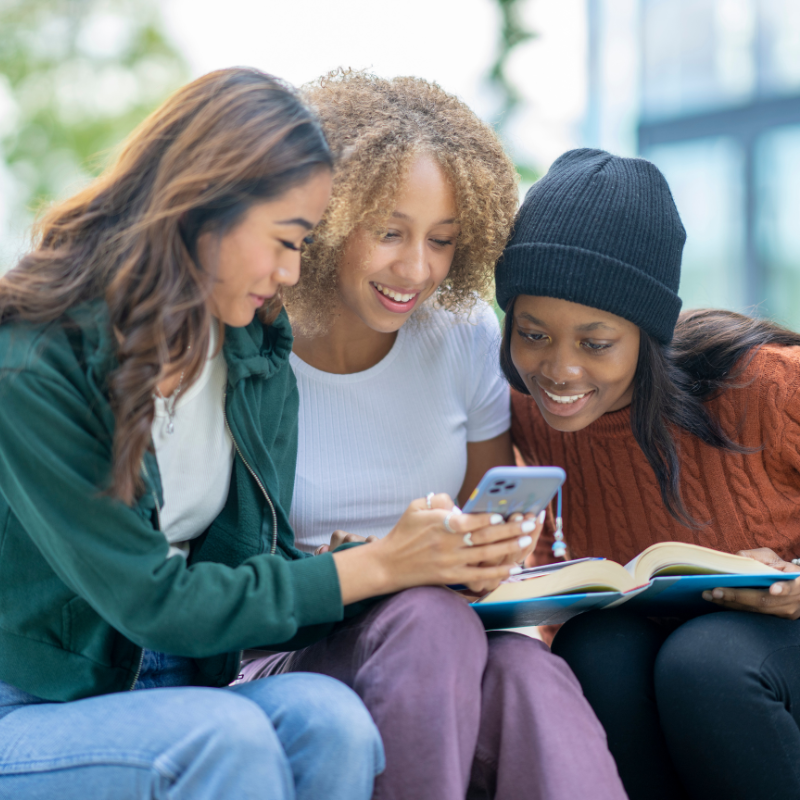 Three young women looking at a phone
