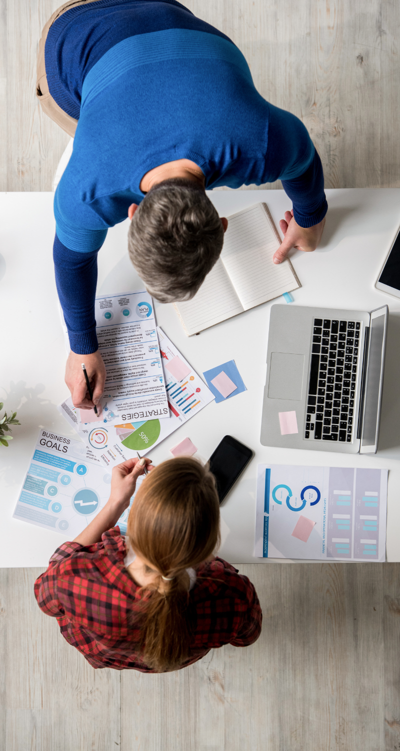 Man and woman at a desk reviewing charts in the workplace