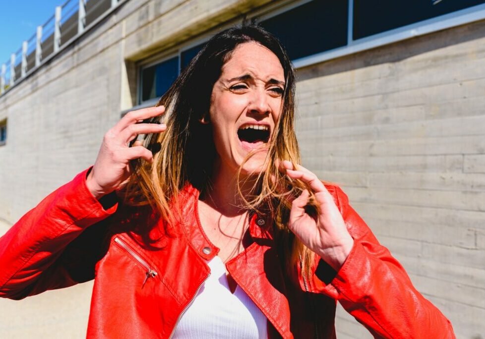 Scared woman is scared and makes a panic face while screaming for help.